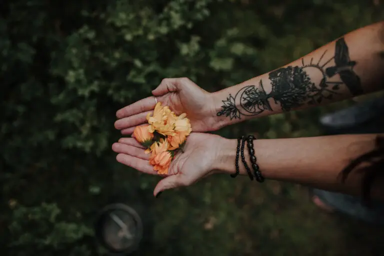 Händer som håller i orange blommor